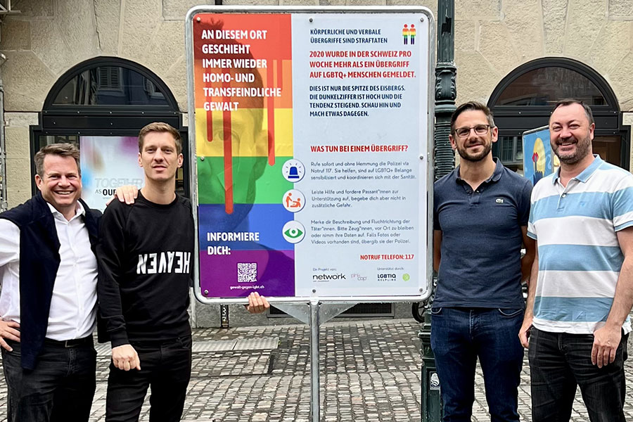 Quattro soci di Network Zurigo con il loro cartellone a Hirschenplatz. (Foto: Network)